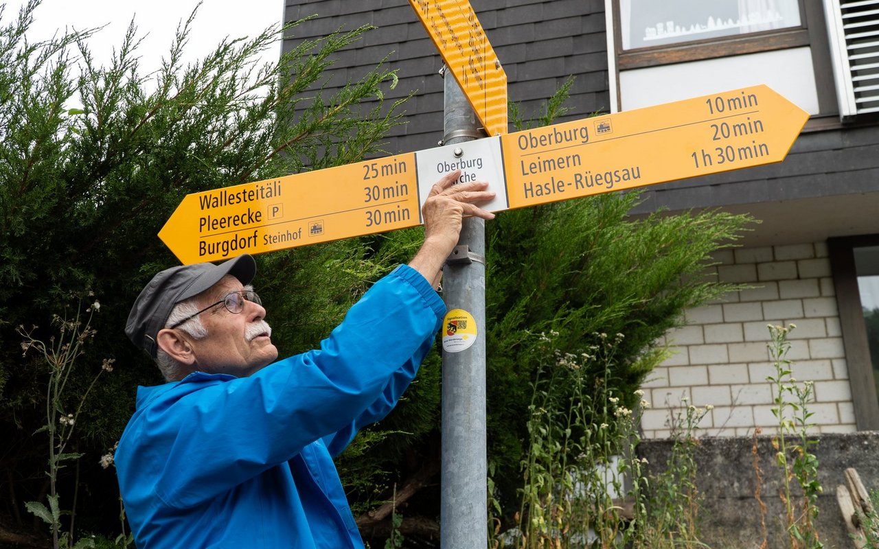 Hier wechselt er einen veralteten Wegweiser durch einen neuen aus. 